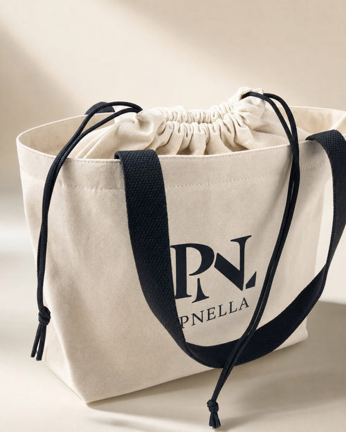 PNELLA signature cream tote bag with black handles and drawstring closure